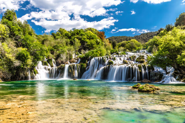 Park Narodowy Krka otoczony drzewami i błękitnym niebem Park Narodowy Krka otoczony drzewami i błękitnym niebem