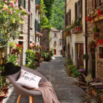 Fototapeta Wąska ulica z kwiatami i roślinami na poboczu