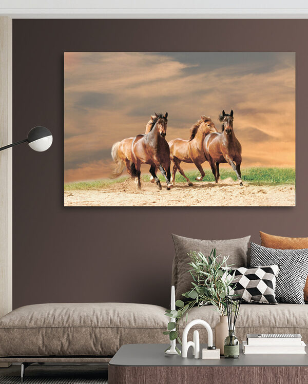A group of horses running on a dirt road