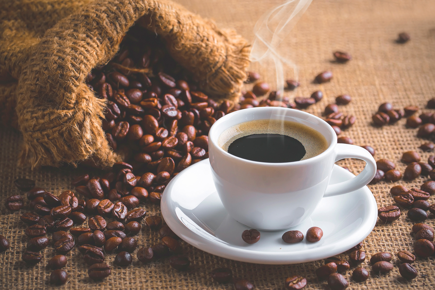 A cup of coffee and a bag of coffee beans