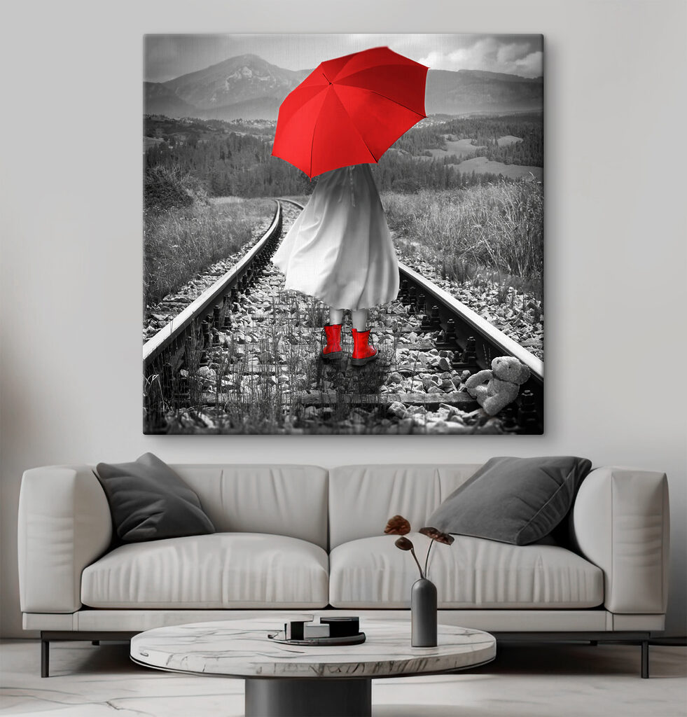 A person with a red umbrella on a train track A person with a red umbrella on a train track