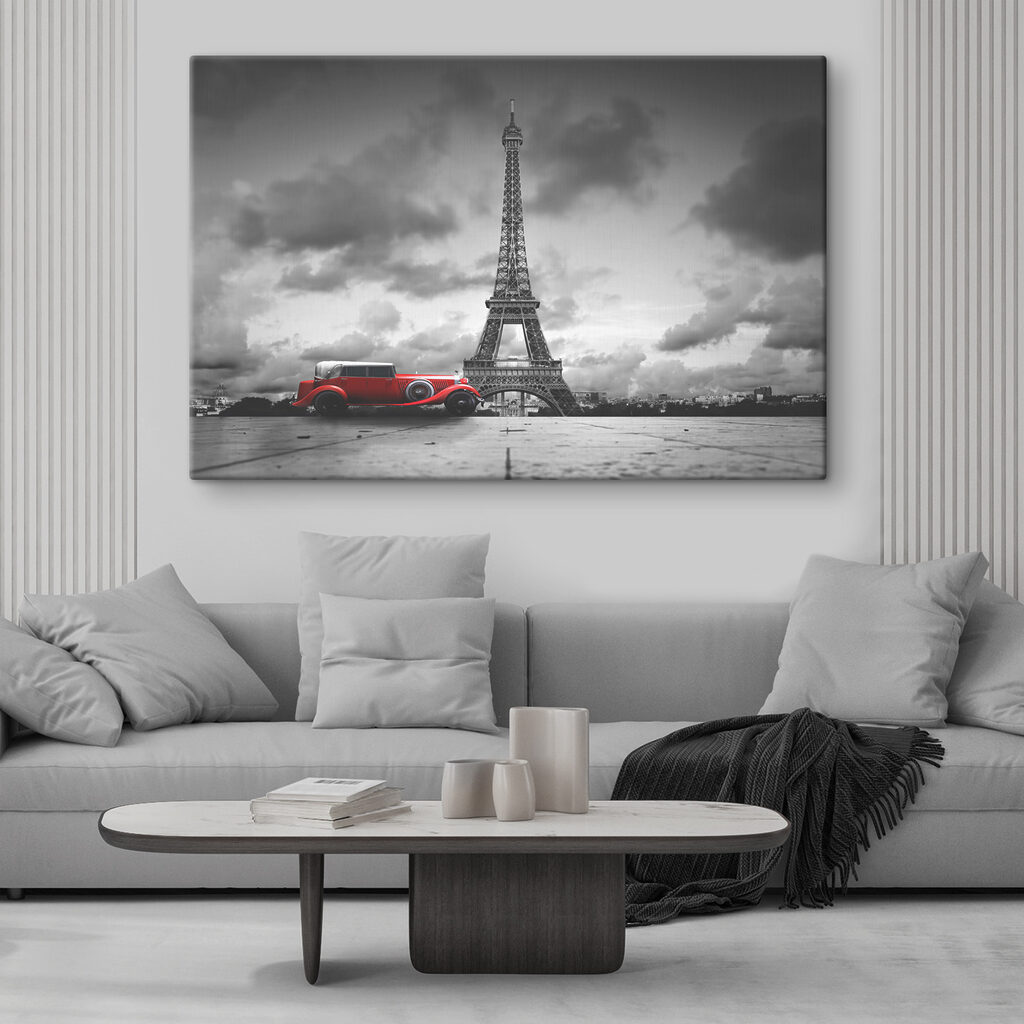 A red car parked in front of a large tower