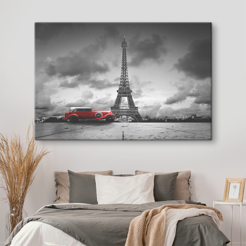 A red car parked in front of a large tower