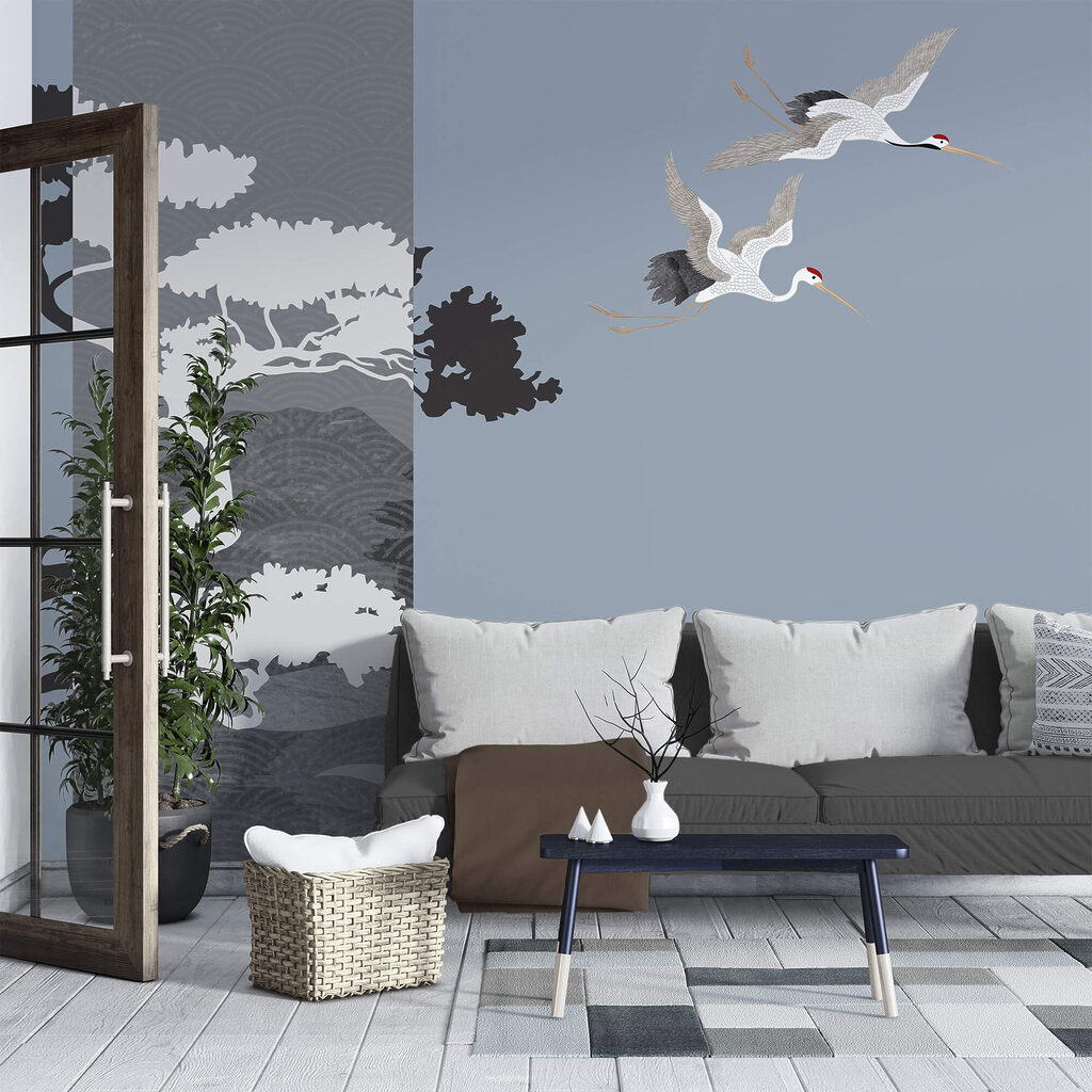 Para żurawi lecących obok drzewa